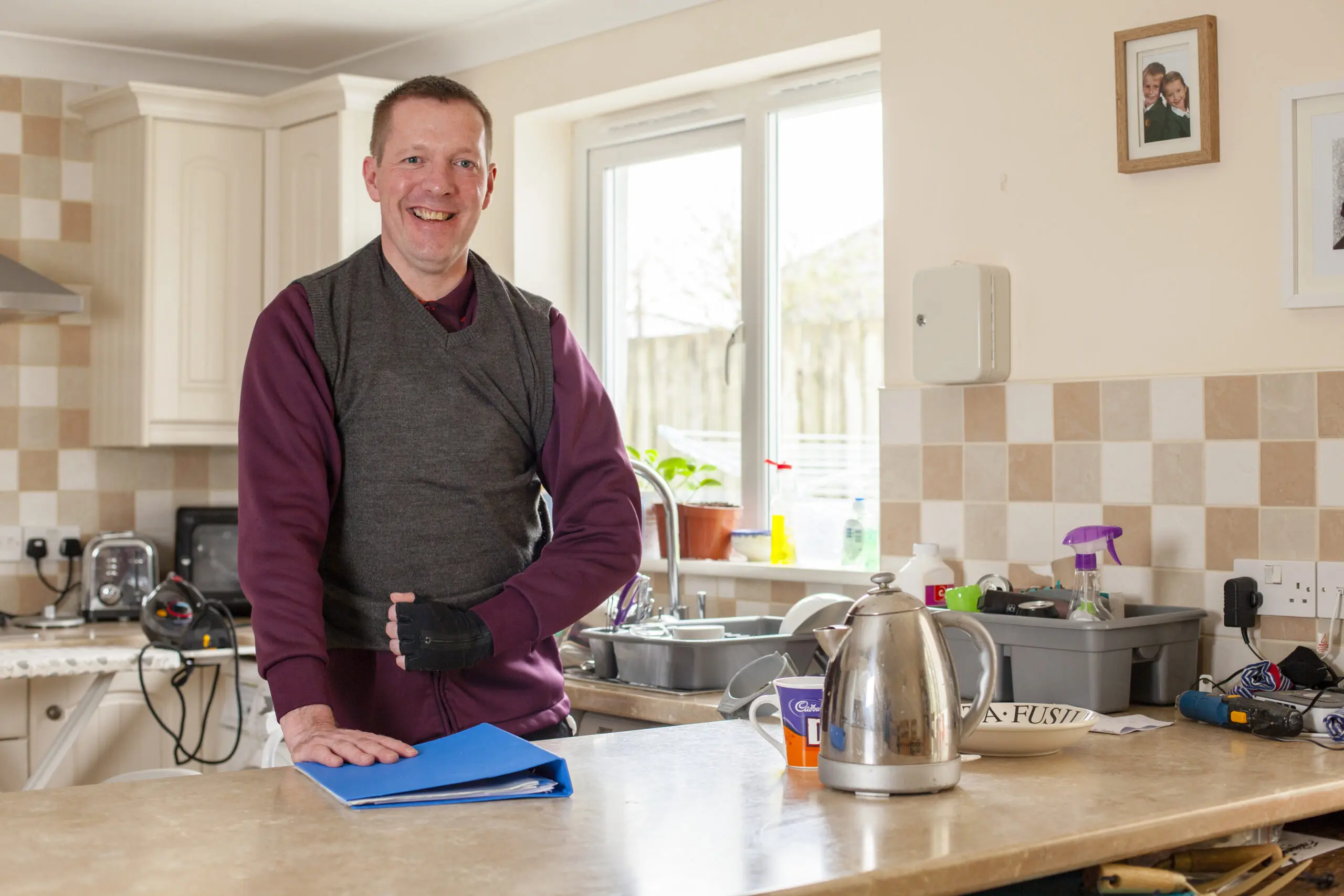 Ian Turner standing in his kitchen. He is smiling and leaning one hand on the counter top